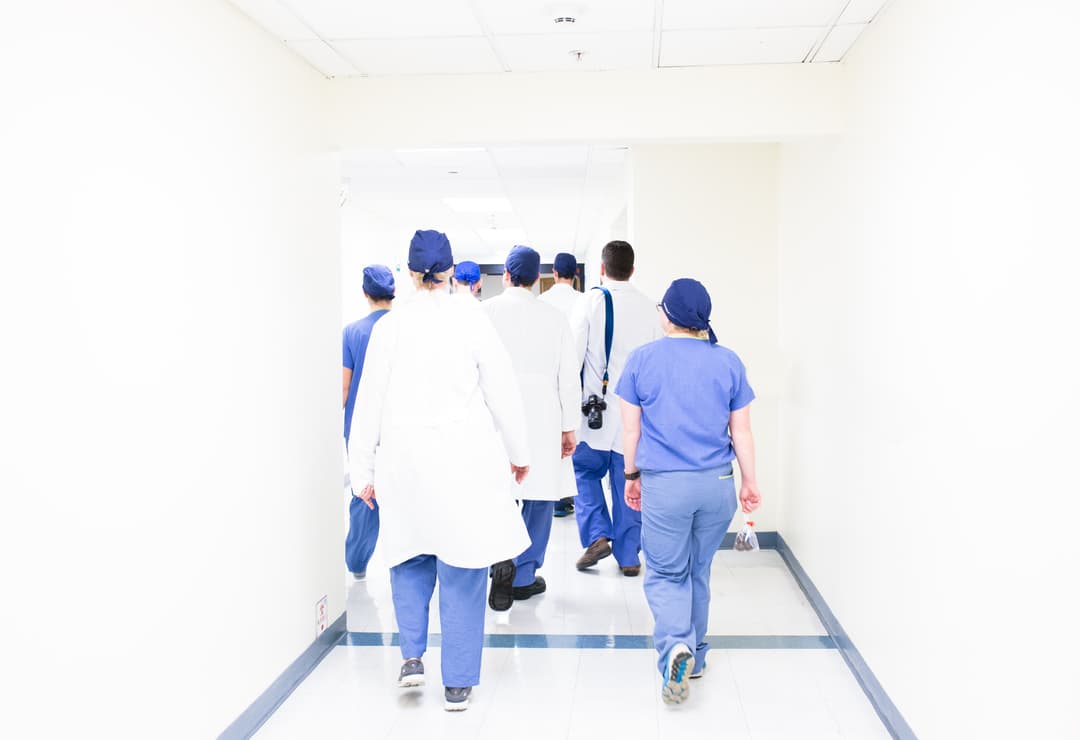 Group of healthcare workers walking through hospital hallway